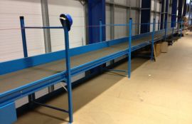 Прямой ленточный конвейер установленный в складском комплексе для транспортировки картонных коробок